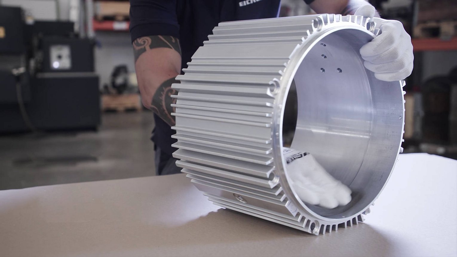 Ein Mitarbeiter von Schmid Metallbearbeitung prüft ein Bauteil mit den Händen