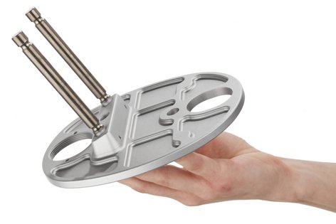Eine Hand hält ein Bauteil aus Metall