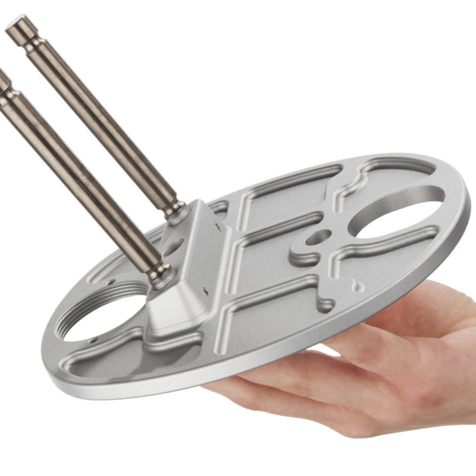 Eine Hand hält ein Bauteil aus Metall