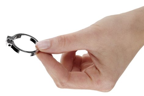 Eine Hand hält ein kleines Bauteil aus Metall zwischen Daumen- und Zeigefinger
