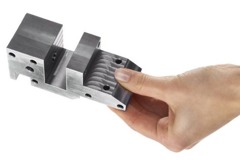 Eine Hand hält ein CNC-Frästeil aus Metall